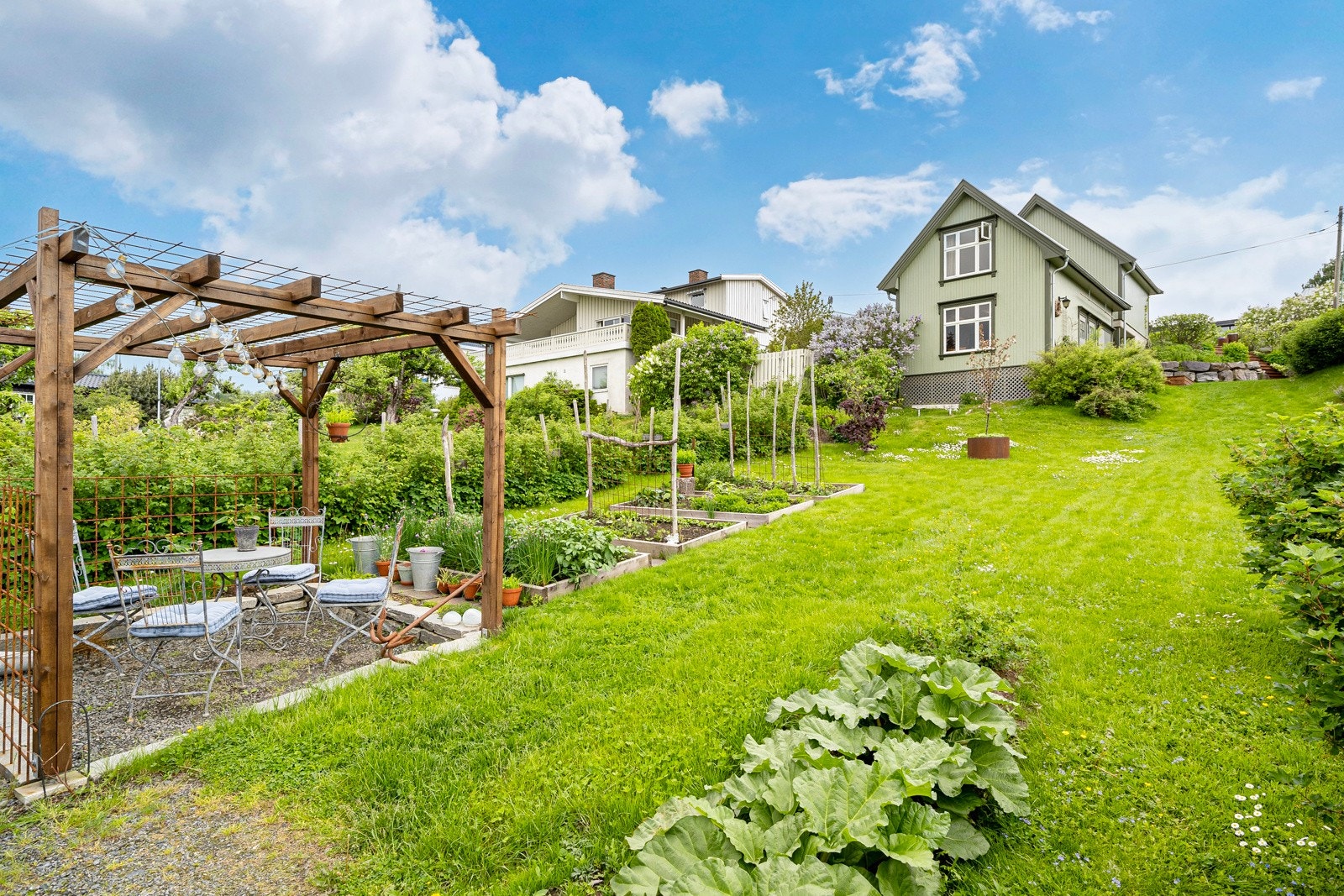 Eiendommen har en flott "gammeldags" hage med mye beplanting, fruktrær, bærbusker, drivhus og pergola Galleribilde