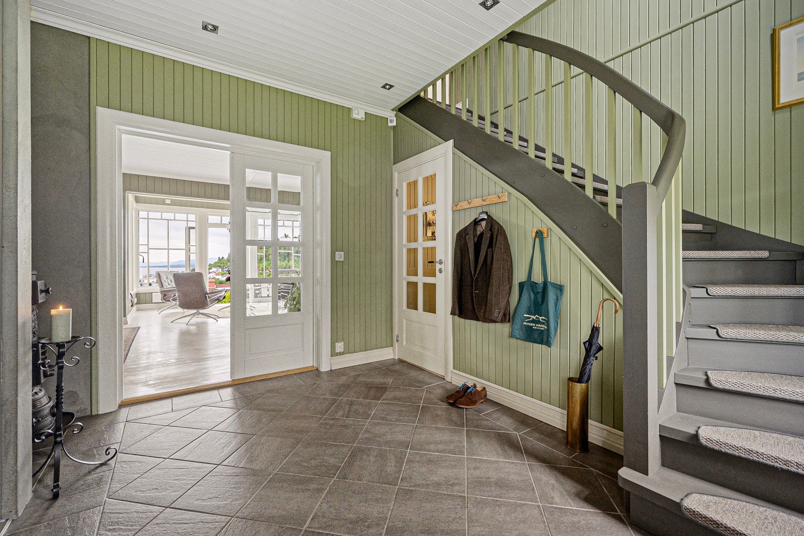 Hallen har flislagt gulv med varme og doble dører mot stuen Galleribilde