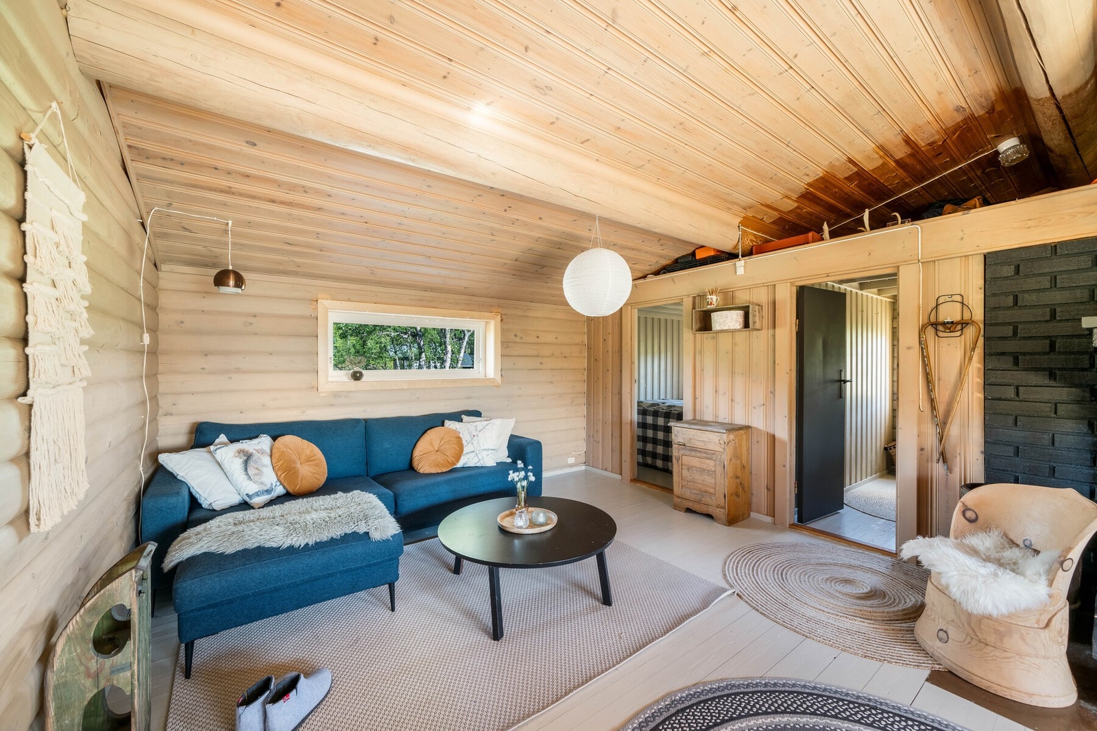 Høyden under taket gir rommet en romslig følelse og flere vinduer i tillegg til verandadør gir mye naturlig lys inn i stuen. Galleribilde