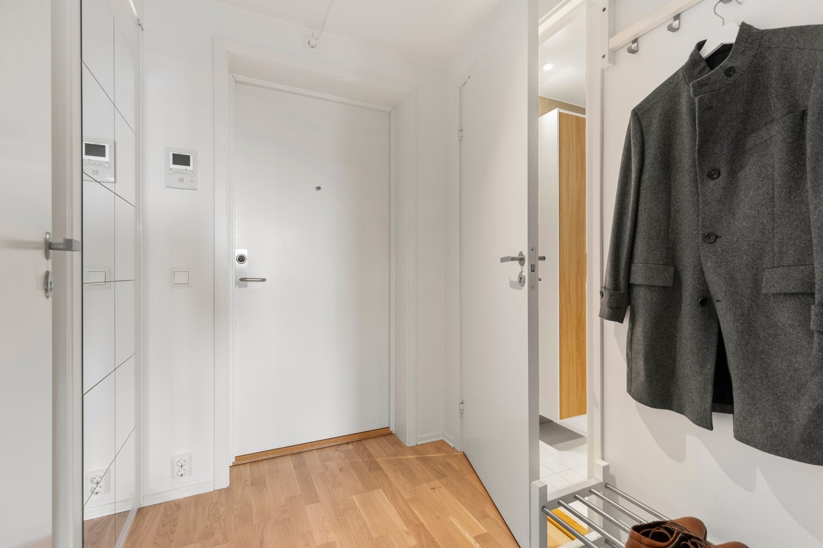 Entreen har lyse overflater med hvitmalte vegger og en lekker tre-stavs parkett på gulv. Galleribilde