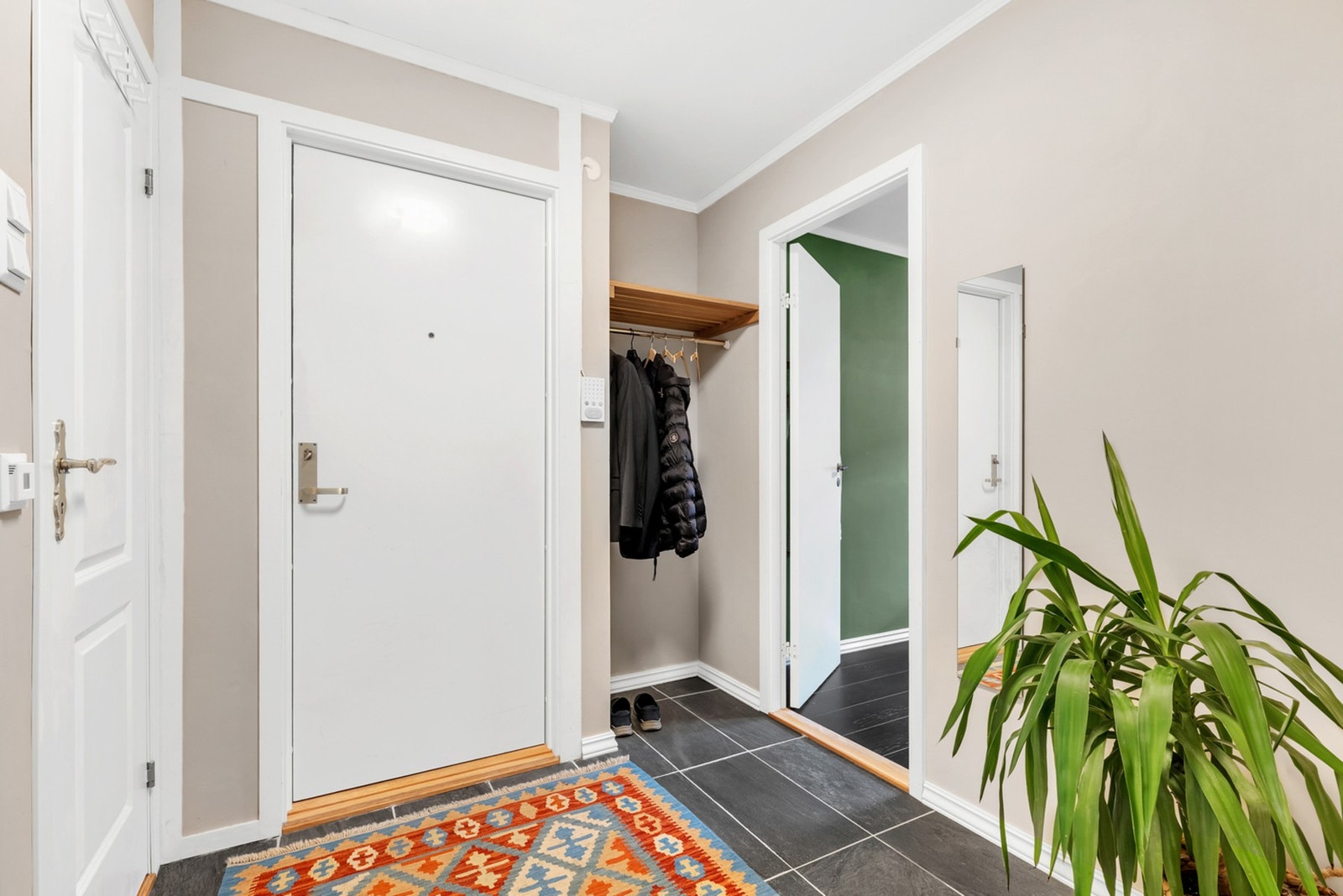 Flislagt entre med plass til sko- og klesoppheng. Galleribilde