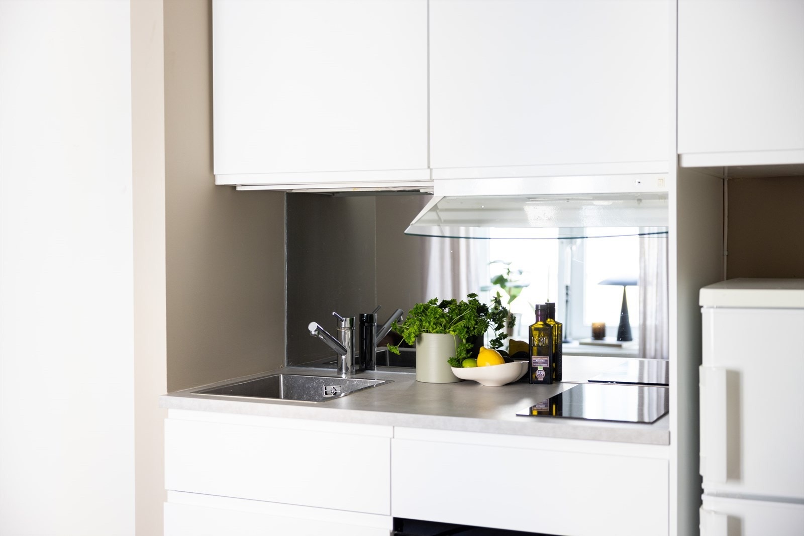 Moderne IKEA kjøkken fra 2019 med god skap- og benkeplass. Kjøkkenet har glatte fronter, laminat benkeplate med nedfelt vaskekum, samt glassplate over benkeplaten fra Drømmekjøkken. Galleribilde