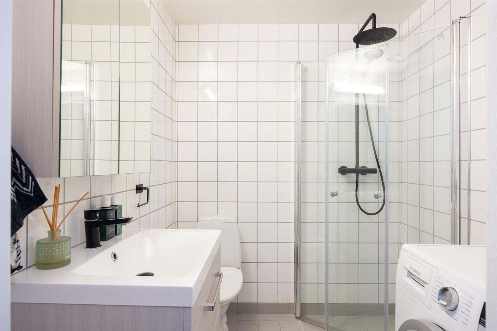 Badet er innredet med klosett, servant med innredning og dusjhjørne med svingbare glassdører. Galleribilde