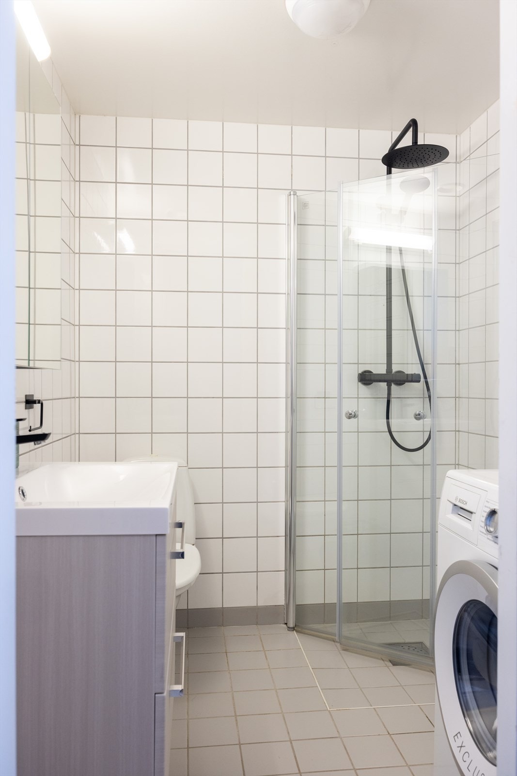 Pent flislagt baderom med elektrisk gulvvarme og opplegg for vaskemaskin. Galleribilde