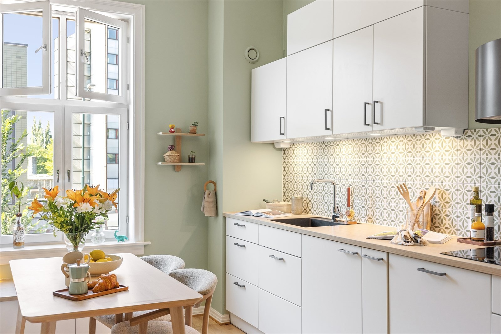 Lys innredning med glatte fronter, fliser på vegg over kjøkkenbenk og benkeplate i tre Galleribilde