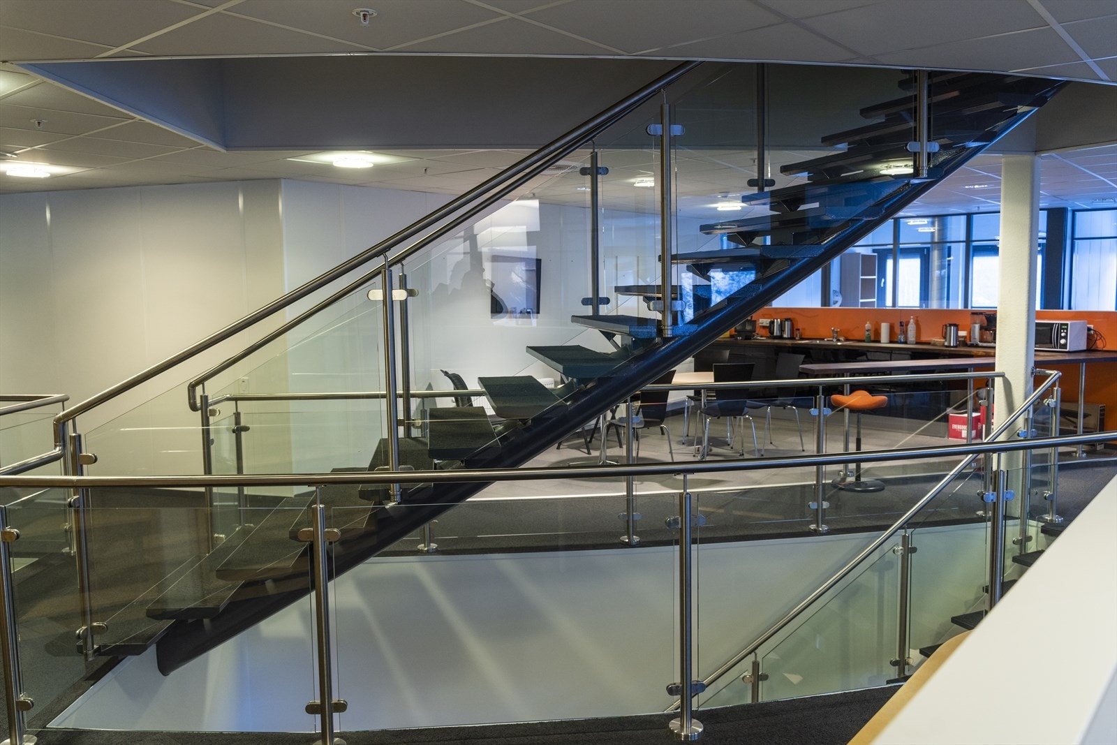 Moderne trappeoppgang med glassrekkverk, som gir et stilrent og åpent inntrykk. Galleribilde