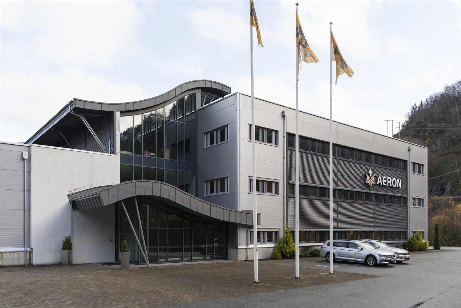 Moderne kontorbygg med bølgende fasade, sentralt beliggende med god synlighet. Tre flaggstenger ved inngangspartiet. Parkeringsplasser tilgjengelig. Galleribilde