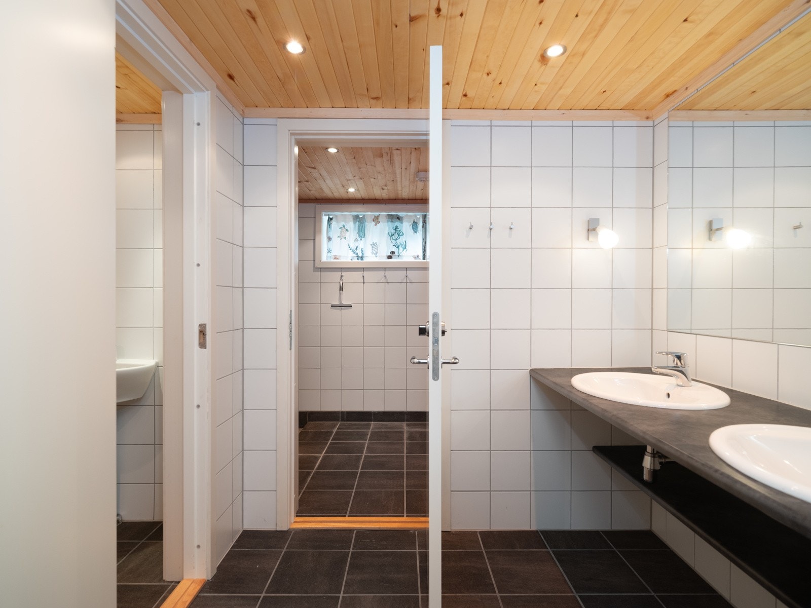 Flislagt baderom med dobbeltservant, speil og downlights i himling. Galleribilde