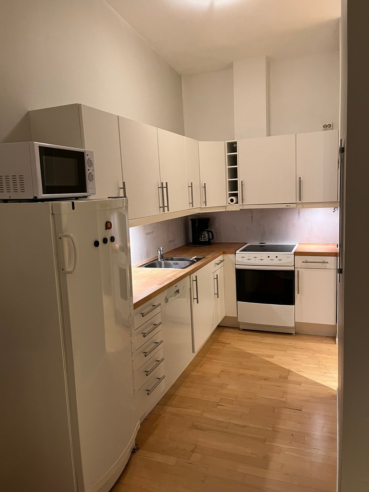 Kjøkken med kjøleskap og mikrobølgeovn Galleribilde