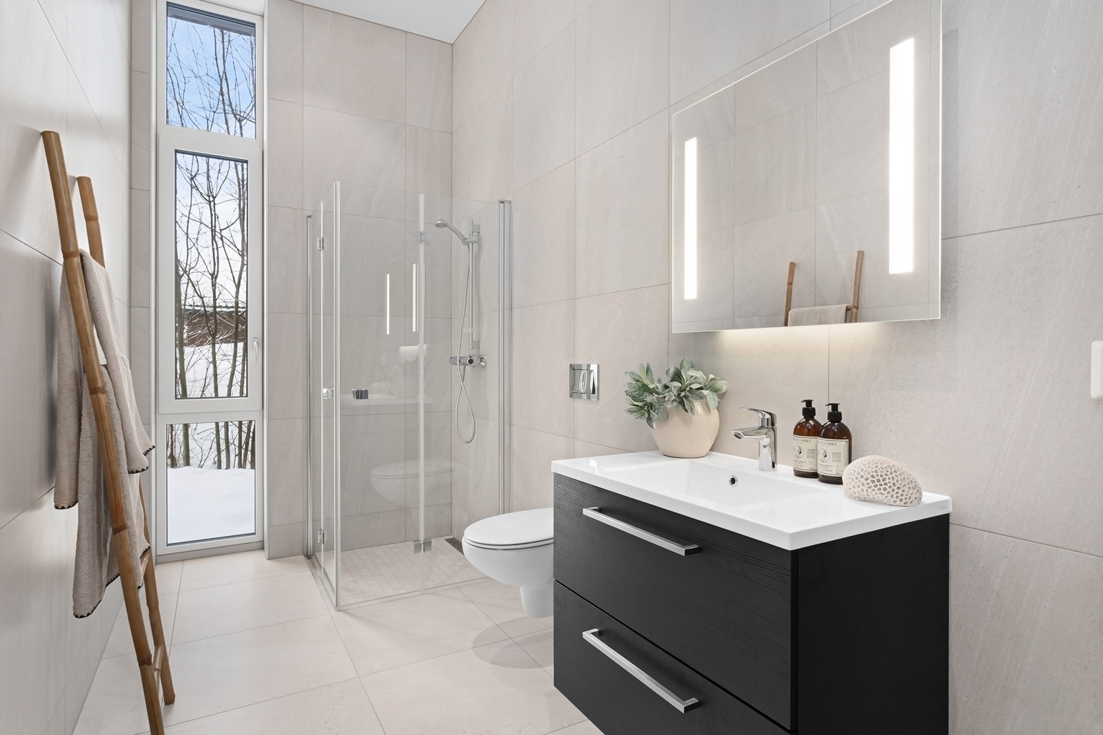 Badet er lekkert innredet med lyse, flislagte overflater. Galleribilde