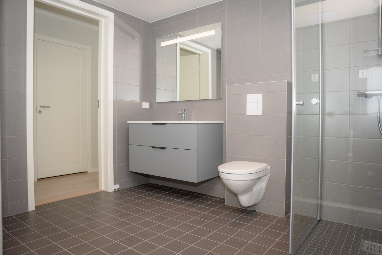 Badet leveres med fliser, varme i gulvet og med en lekker innredning fra HTH. Galleribilde