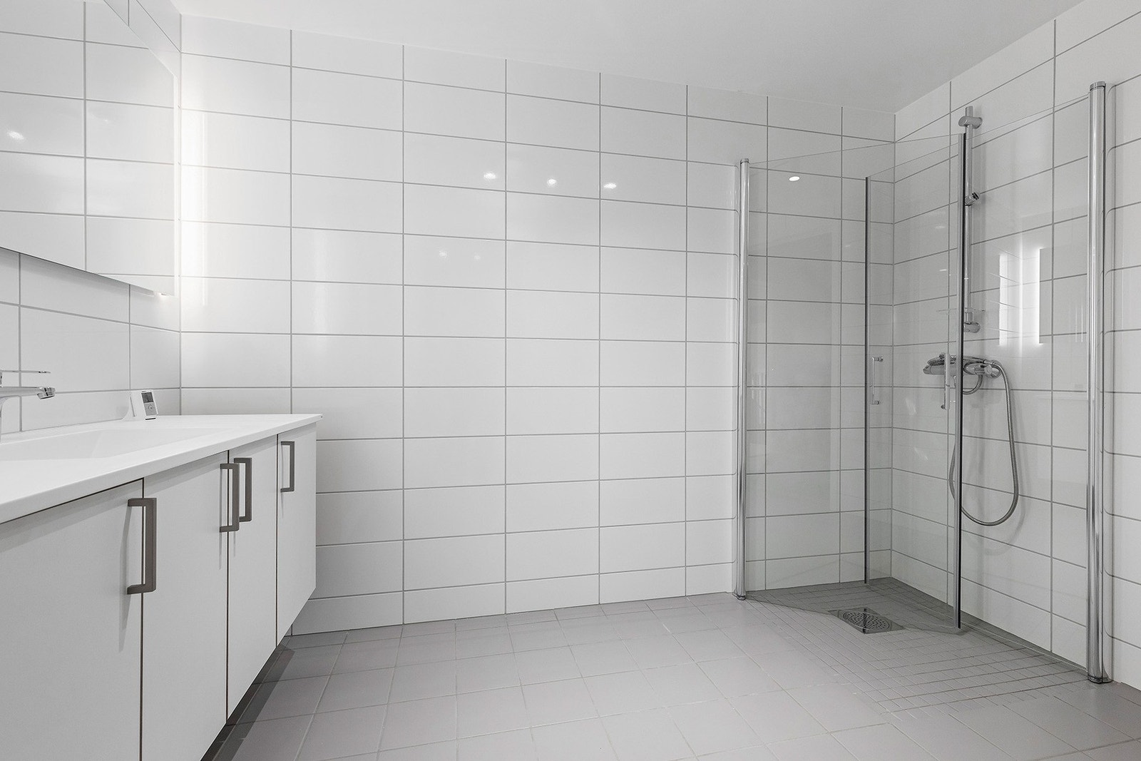 Flislagt baderom med gulvvarme. Her har du god belysning og baderomsinnredning med mye oppbevaringsplass. Galleribilde