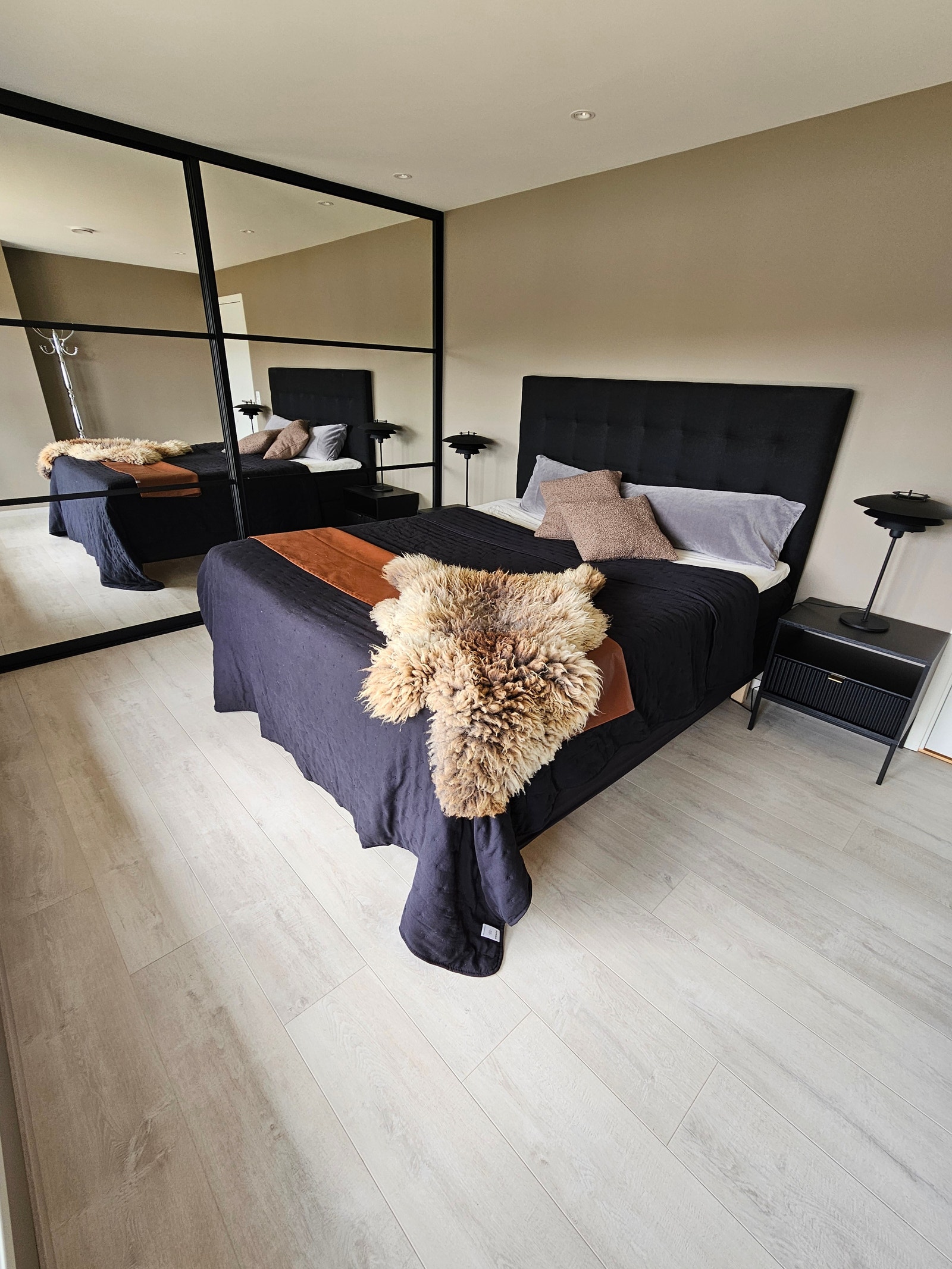 Hovedsoverom med ny skyvedørsgarderobe og utsikt mot sjøen fra sengekanten. Galleribilde