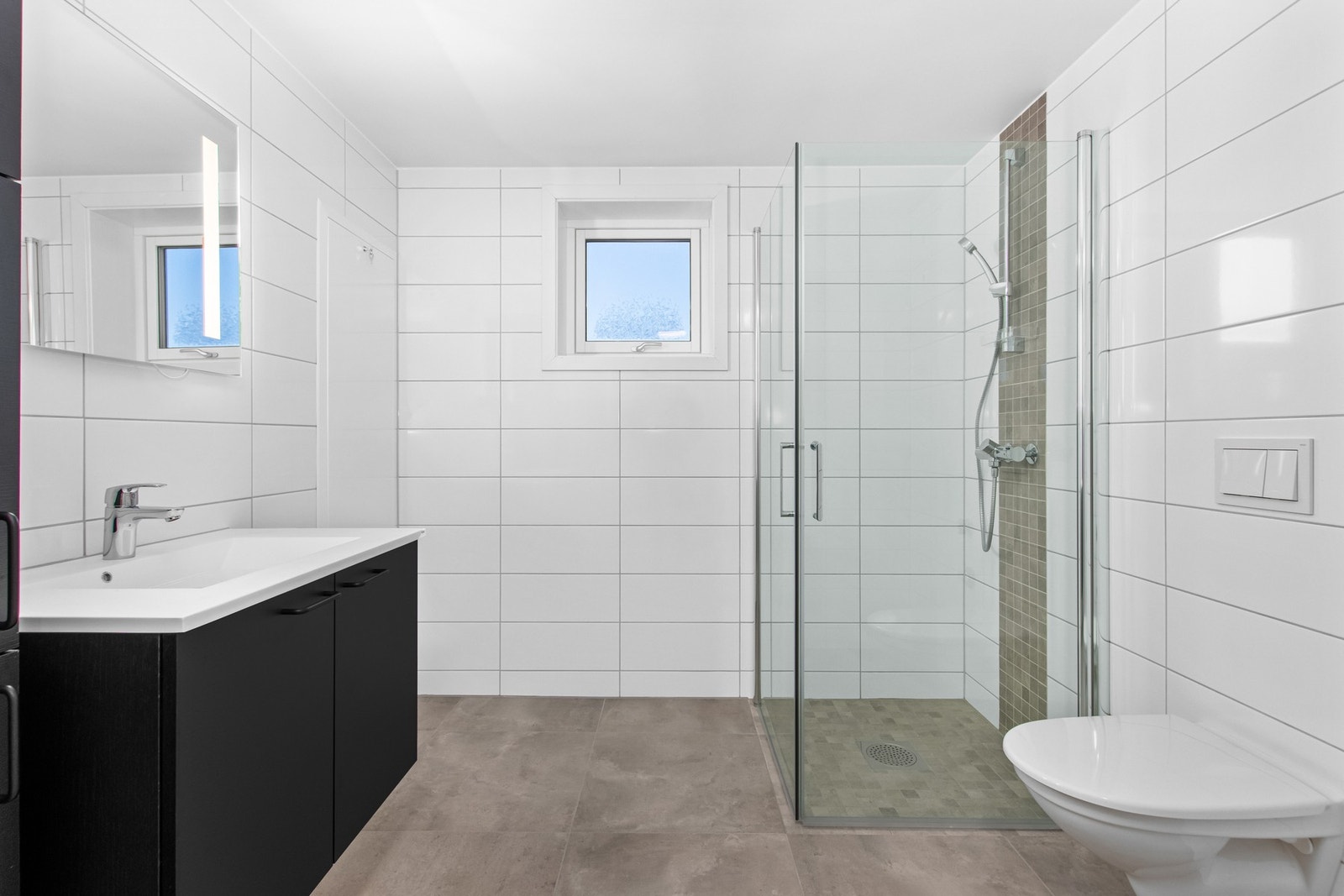 Flott bad med romslig baderomsinnredning. Her er det kostet på med ekstra stor fliser og mosaikk i dusjhjørnet. Galleribilde