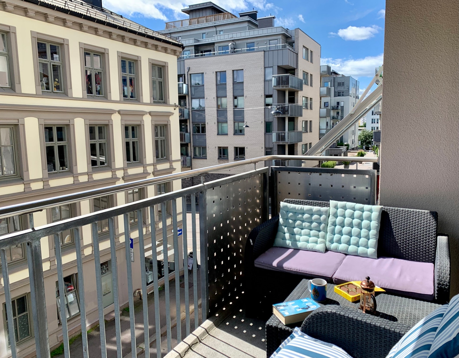 Balkong med gode solforhold, to-seters sofa, klappbar solstol og to hagestoler Galleribilde