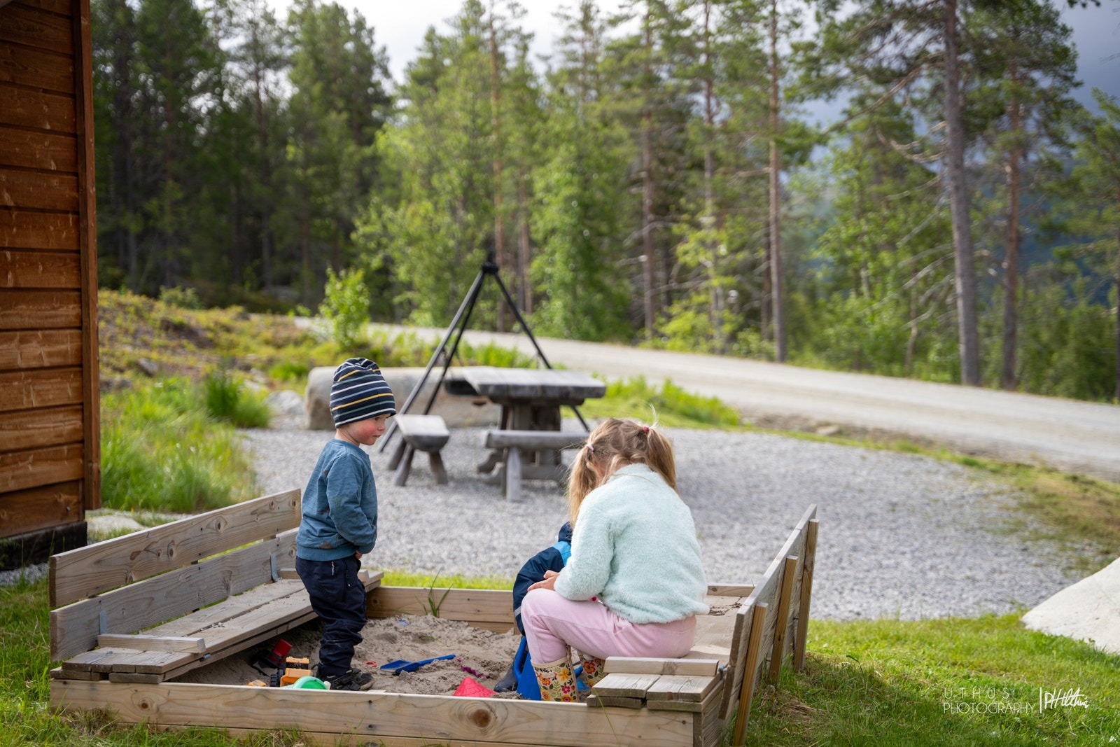 Fellesområde med bord/benker og bålpanne, samt sandkasse og storhuske for barna Galleribilde