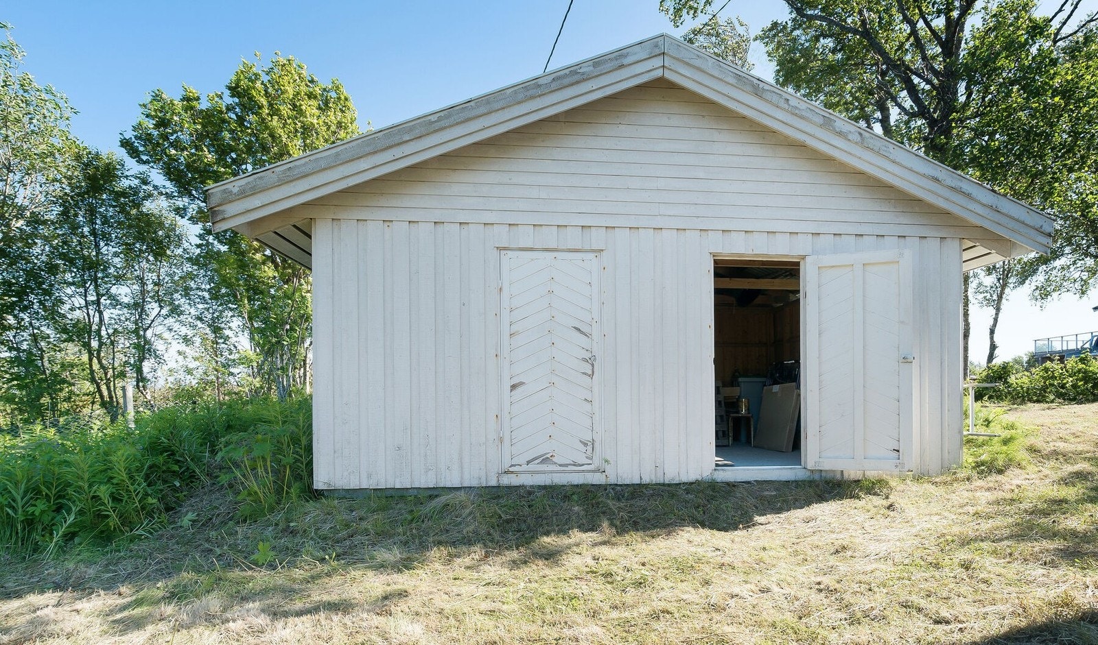 Stort uthus i hagen. Dørene er malt etter bildene er tatt Galleribilde