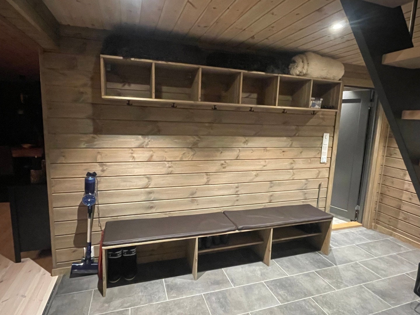 God plass til sko, støvler, luer, votter og jakker. Skinn til utebenker på toppen av hylla Galleribilde