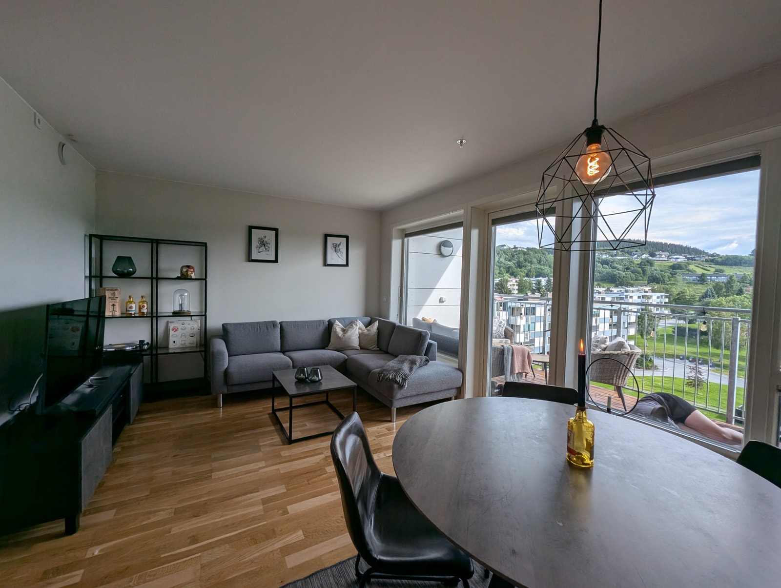 Store vindusflater mot stuen gir en lys og trivelig leilighet.
Kona som etter beste evne forsøker å gjemme seg på balkongen medfølger ikke i leieforholdet. Galleribilde