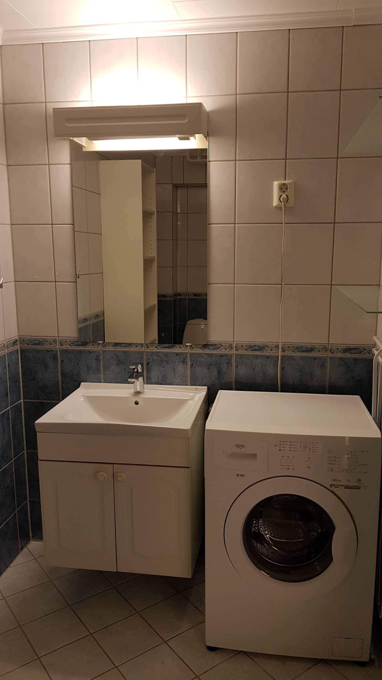 Bad med vask, speil og vaskemaskin Galleribilde