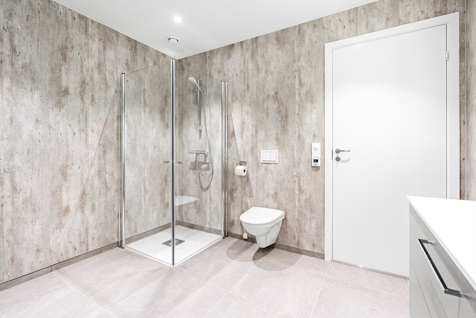 Badet er romslig med fliser på gulv og våtromsplater på vegg Galleribilde