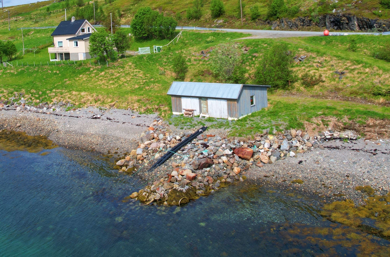Bilde viser eiendommen med bolig og naust. Galleribilde