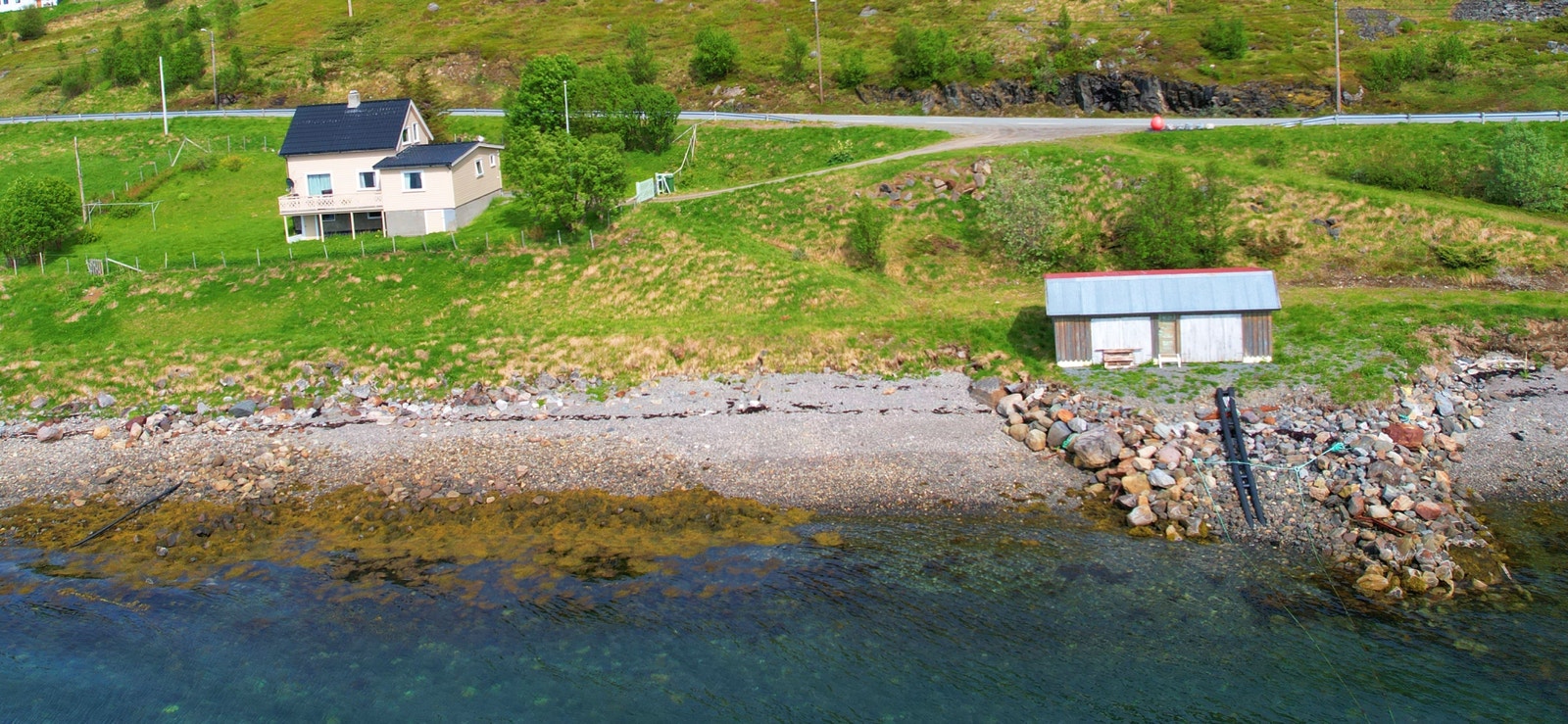 Bilde viser eiendommen med bolig og naust. Galleribilde