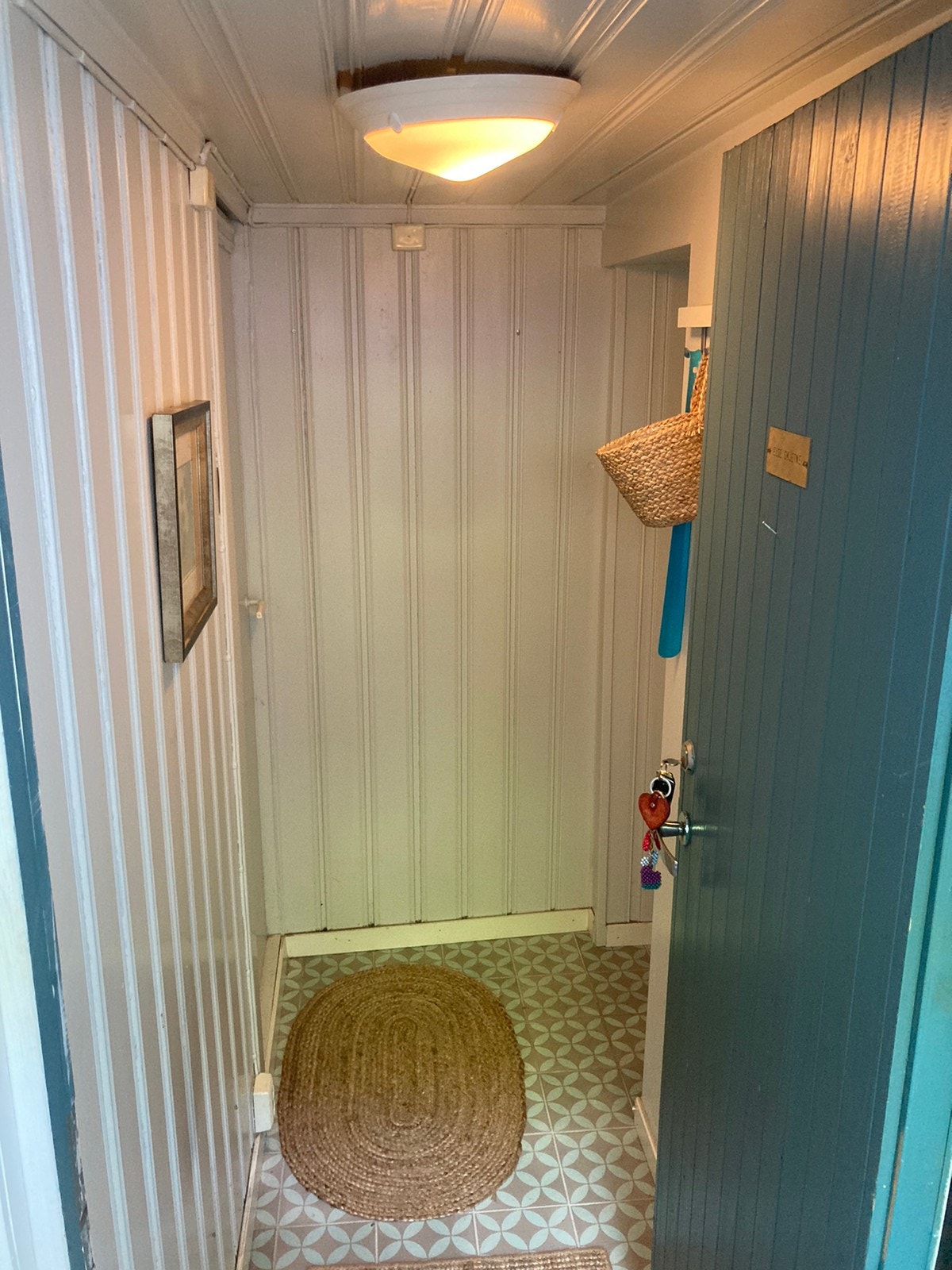 Liten entré, panelovn og sko oppbevaring på plass etter bildet ble tatt Galleribilde