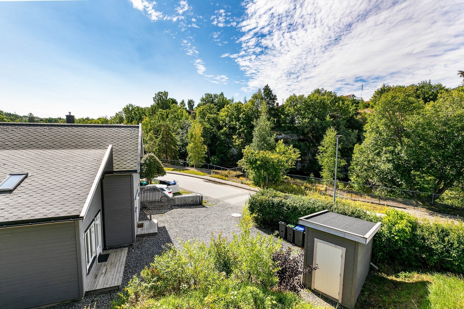 Stor gårdsplass med plass til flere biler, et papirflykast fra elven. Galleribilde