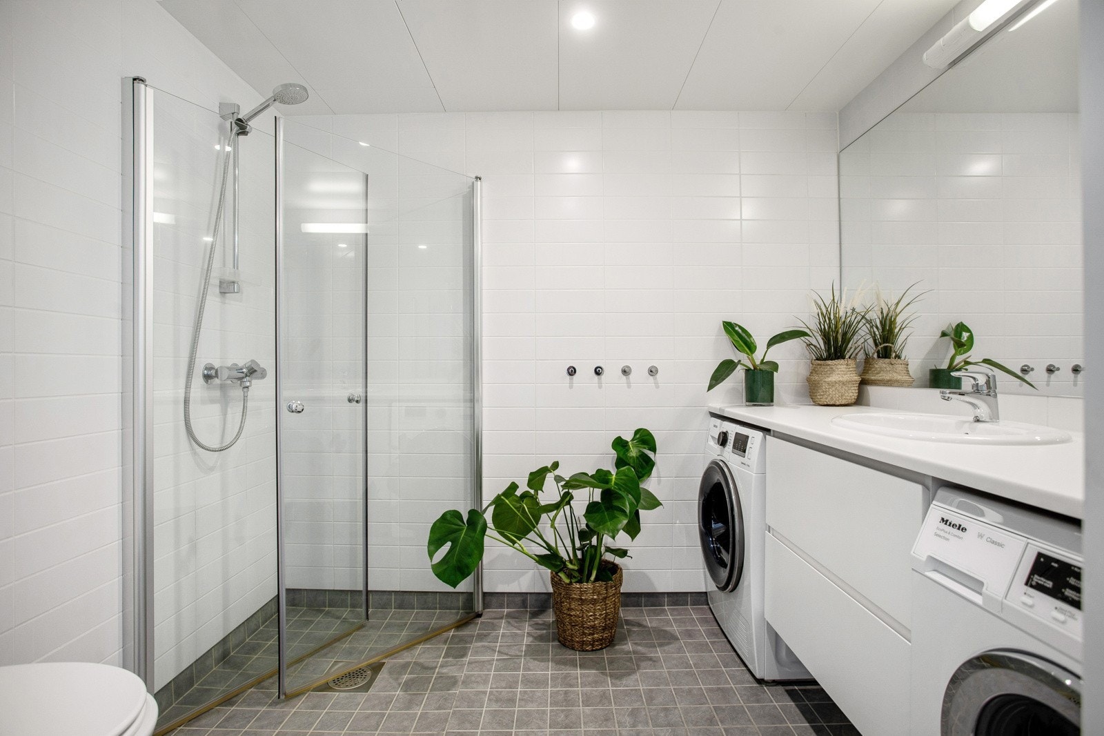 Leiligheten har et lyst og moderne flislagt baderom fra byggeår 2016. Baderommet har mørke fliser på gulv med gulvvarme, lyse fliser på veggene og downlights i himlingen. Galleribilde