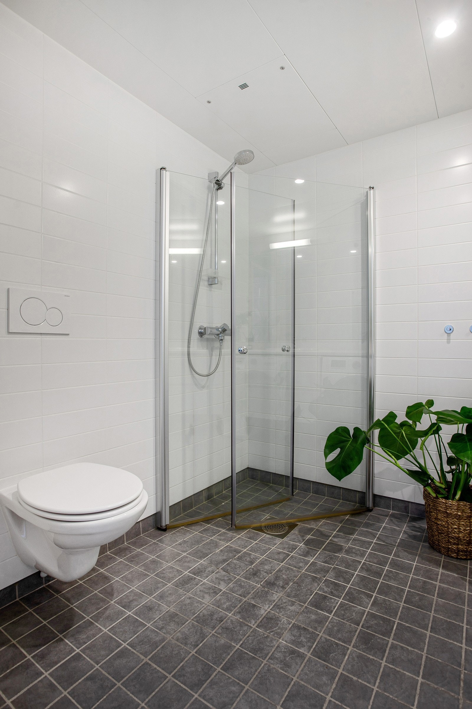 Baderommet er også utstyrt med dusjhjørne med innfellbare glassdører og vegghengt toalett. Mekanisk avtrekk i himling. Galleribilde