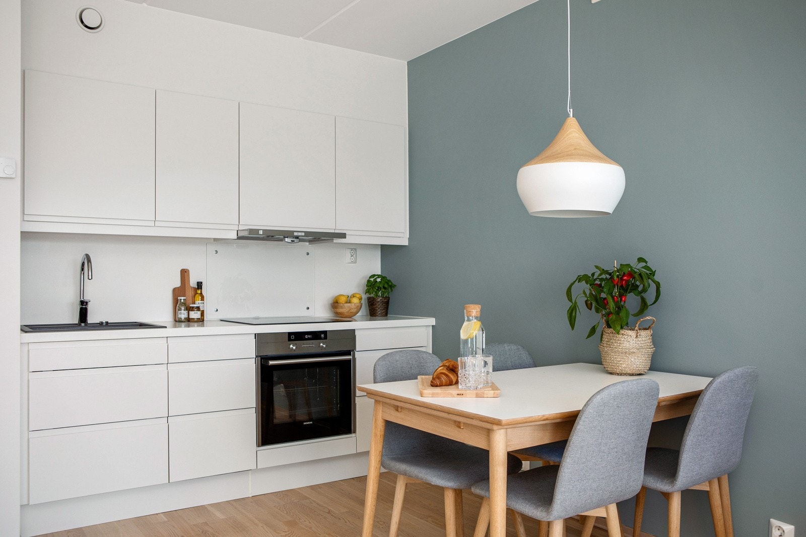 Kjøkken med integrerte hvitevarer; kjøpeskap med frysedel, oppvaskmaskin, komfyr og steketopp Galleribilde