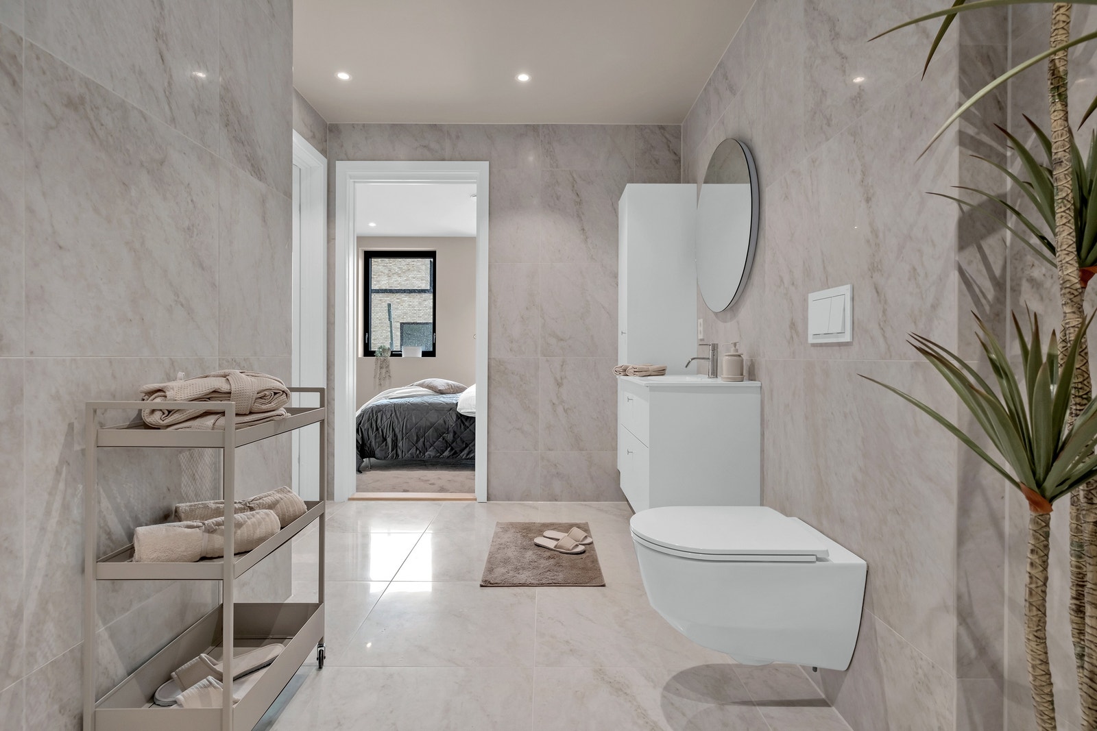 Lekkert fliselagt bad med dør inn til hovedsoverommet Galleribilde