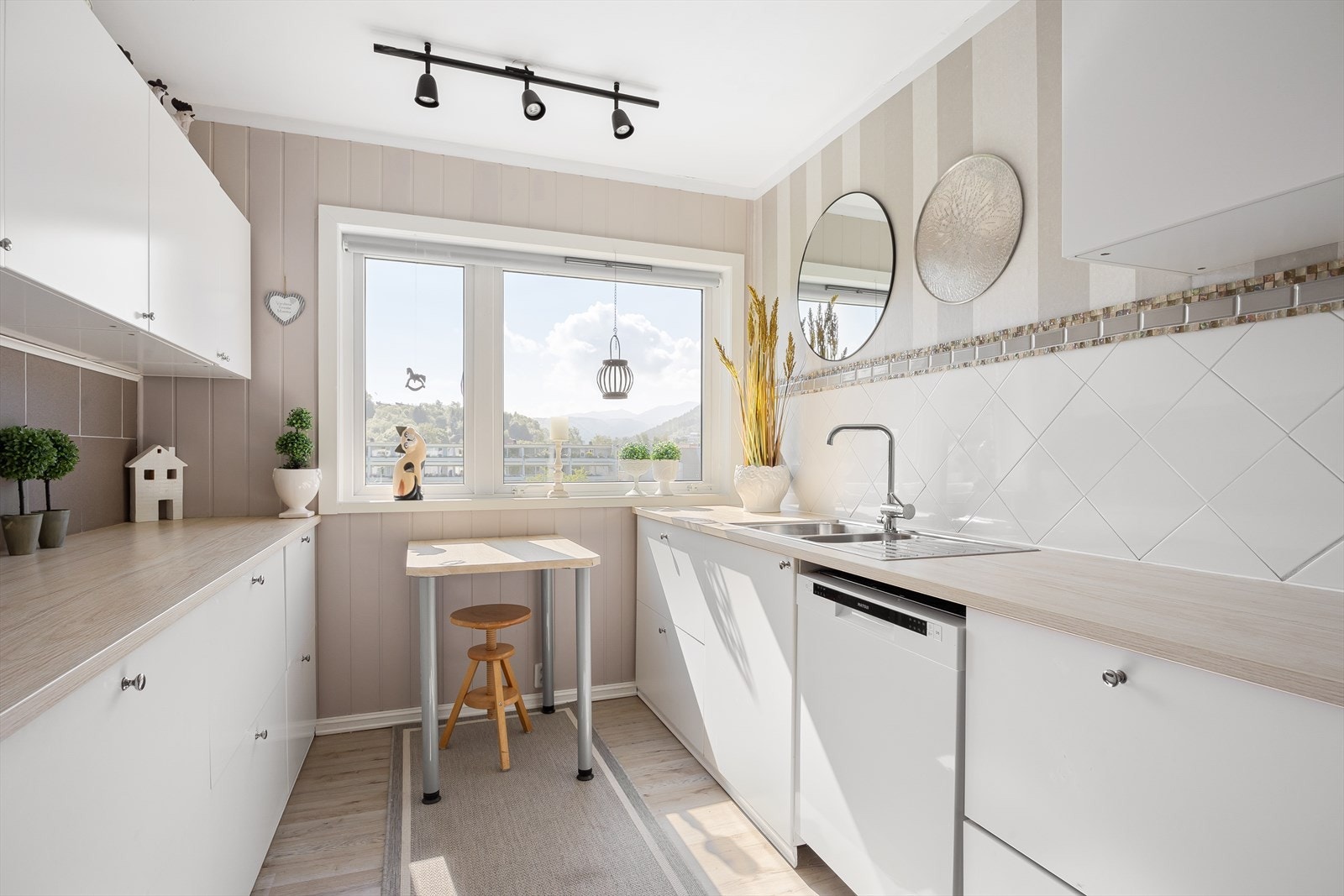 Kjøkkenet har hvite slette fronter og fikk ny benkeplate og servant i 2020 Galleribilde