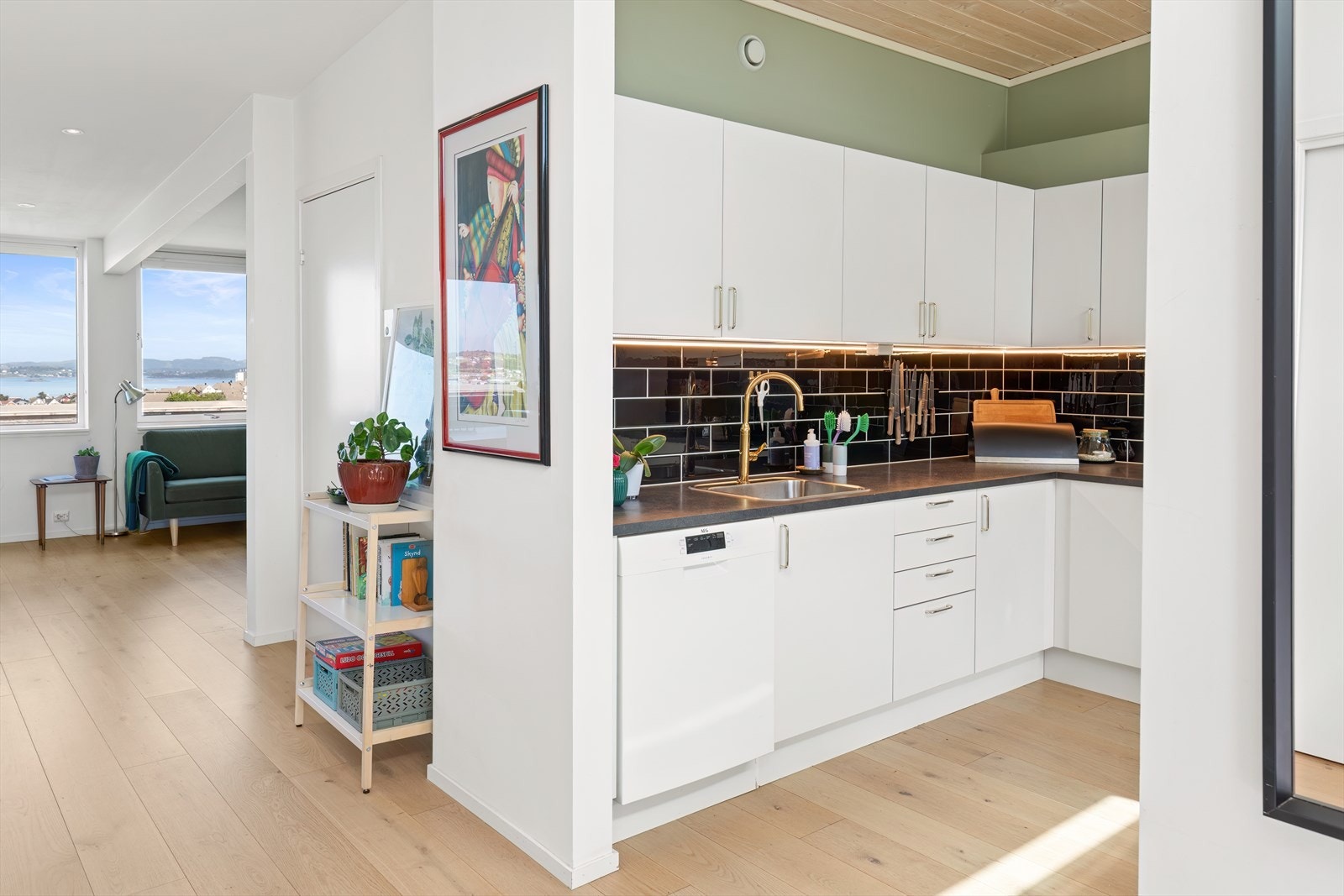 Tidløs kjøkkeninnredning med slette, hvite fronter og benkeplate av laminat. Galleribilde