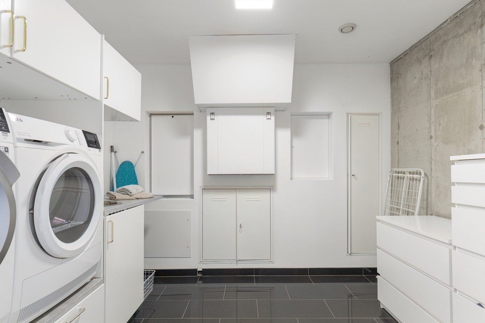 Praktisk vaskerom med god innredning og fliser på gulv. Her er det også vannbåren gulvvarme. Galleribilde