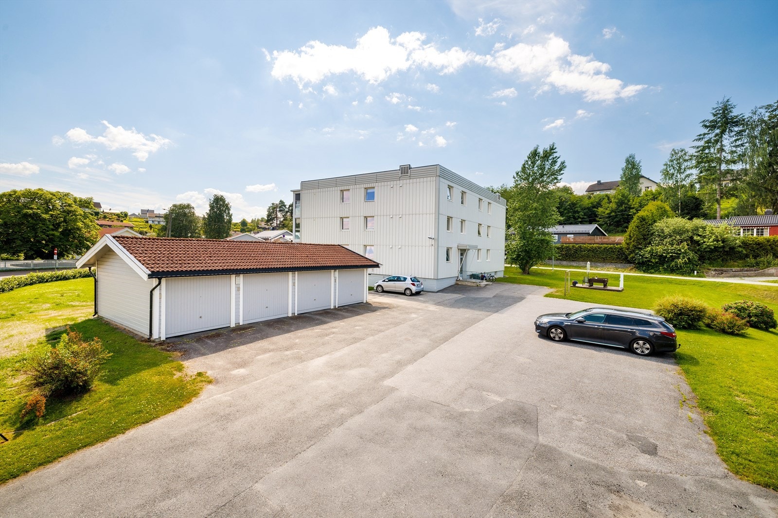 Borettslagets tomt er opparbeidet med store grøntarealer, asfaltert parkering og garaseanlegg. Galleribilde