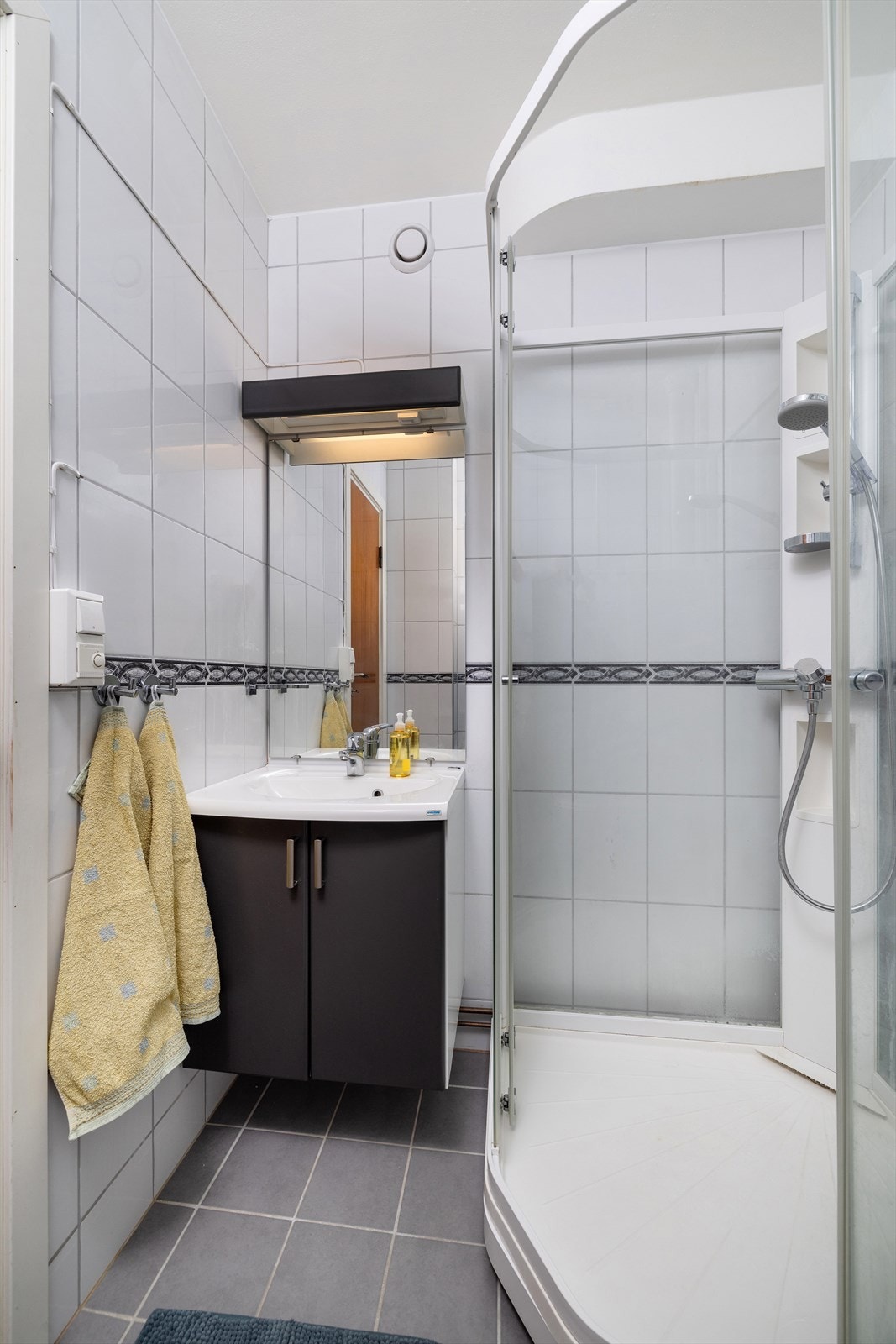 Alltid trygt med dusjkabinett, det er varme i gulv, og baderomsinnredning med speil og lys over Galleribilde