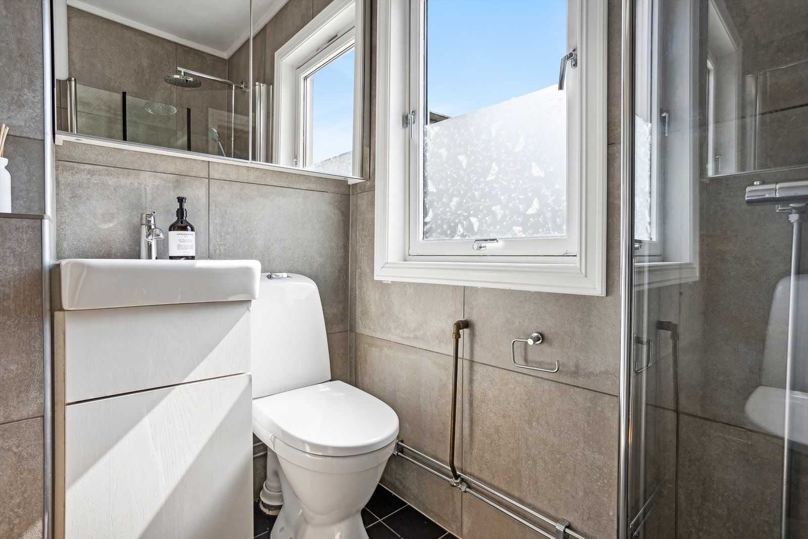 Flislagt, funksjonelt baderom med vindu - Badet er av eldre dato Galleribilde
