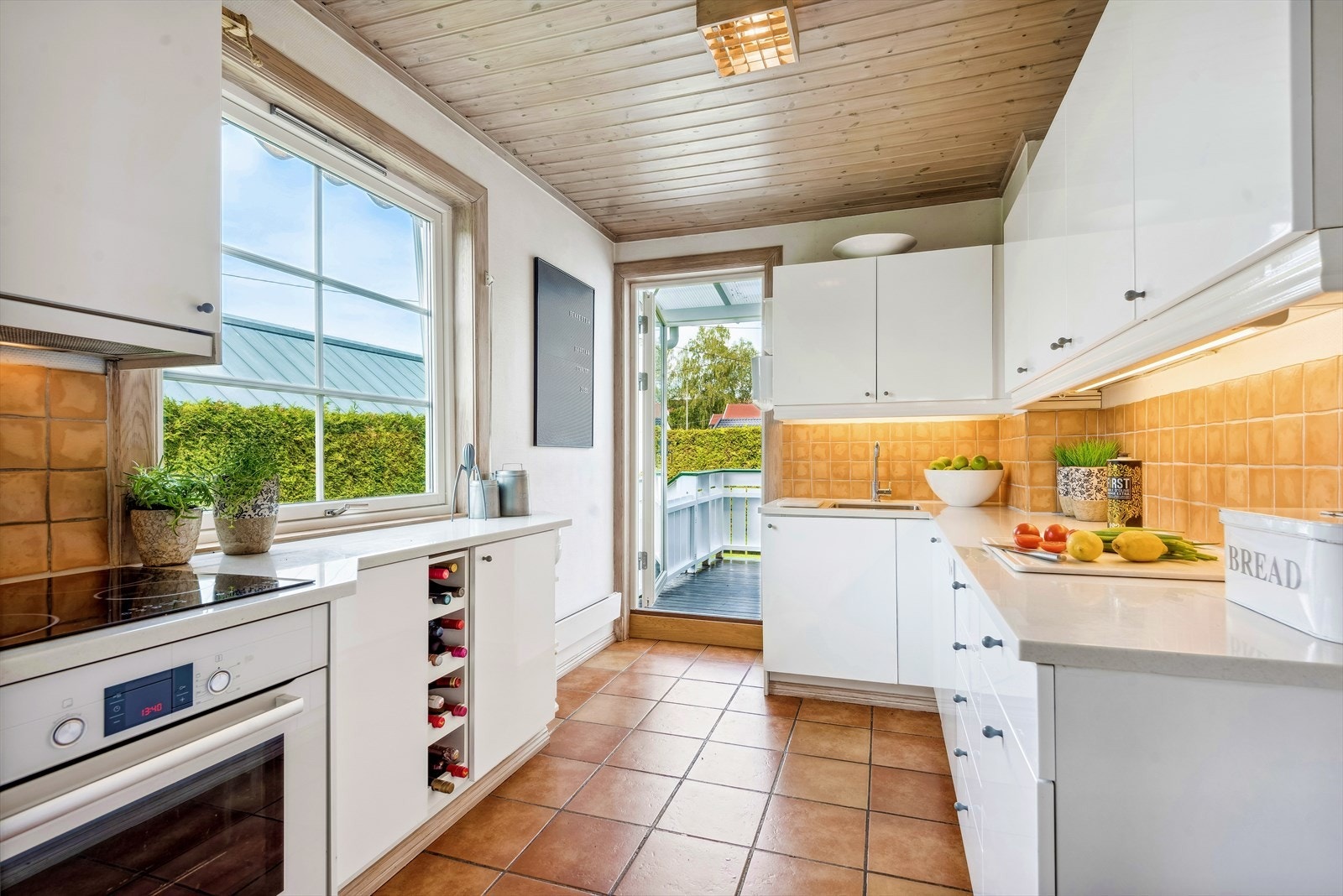 Lys kjøkken utført med høyglanset fronter, benkeplate av Corian og integrert hvitevarer som består av induksjonstopp og stekeovn og ventilator samt opplegg for oppvaskmaskin Galleribilde