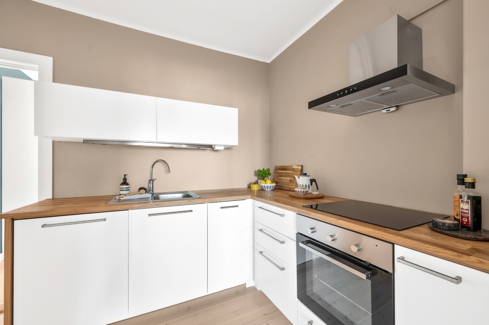 Kjøkkenet har en praktisk løsning vegg-i-vegg med stuen, sosialt, samtidig som det er noe skjermet fra stuen. Galleribilde