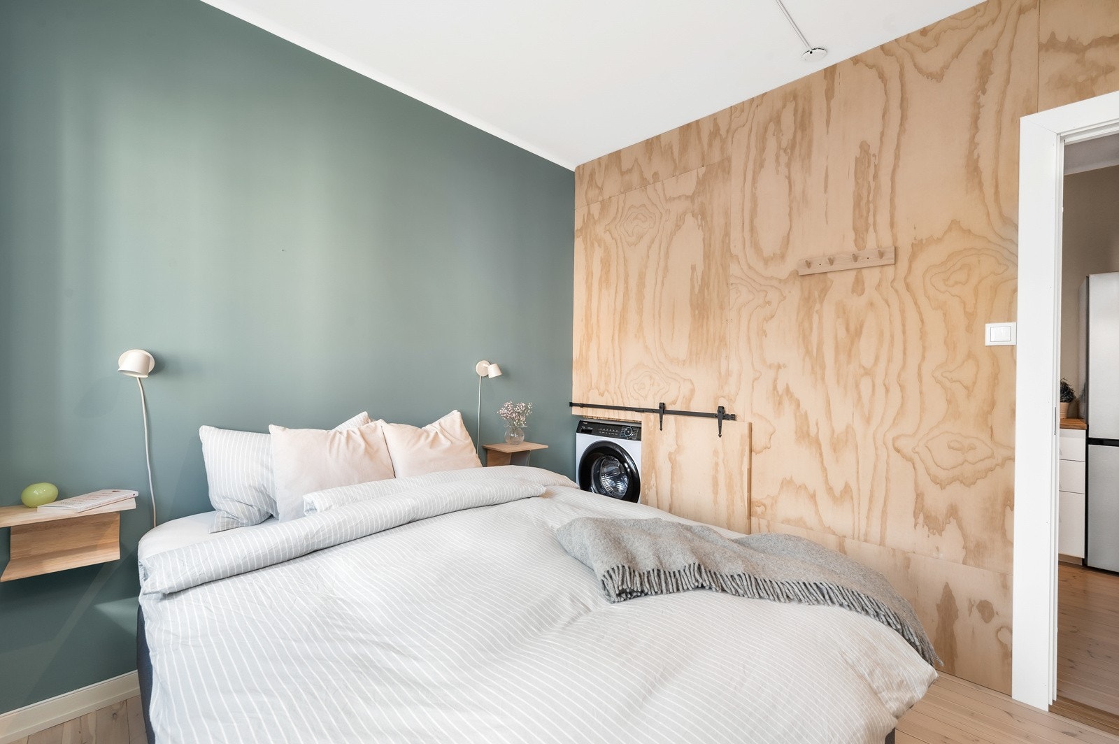 Veggen inn mot kjøkkenet har et eget "rom" for vaskemaskin. Vaskemaskinen er ny i 2023 og vil følge boligen. (Det er også fellesvaskeri i aksjelaget). Galleribilde