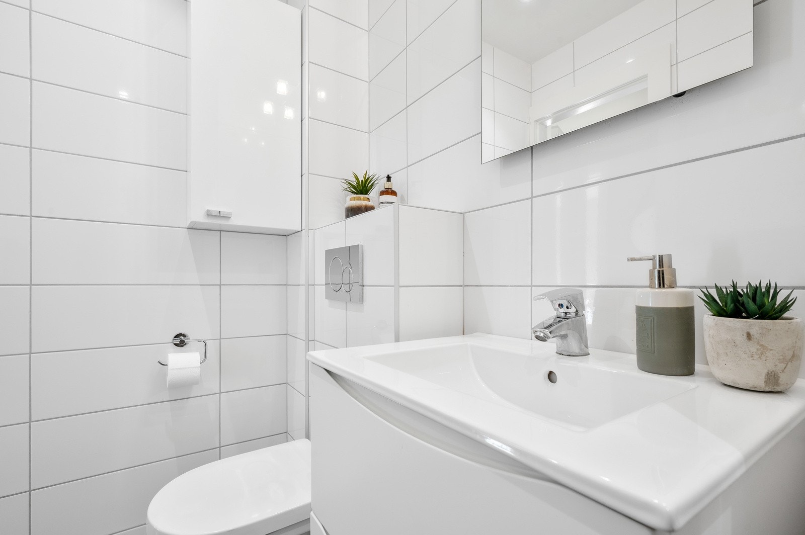 Videre har du vegghengt servantskap med ovenpåliggende servant og ett-greps armatur, og vegghengt toalett. Galleribilde