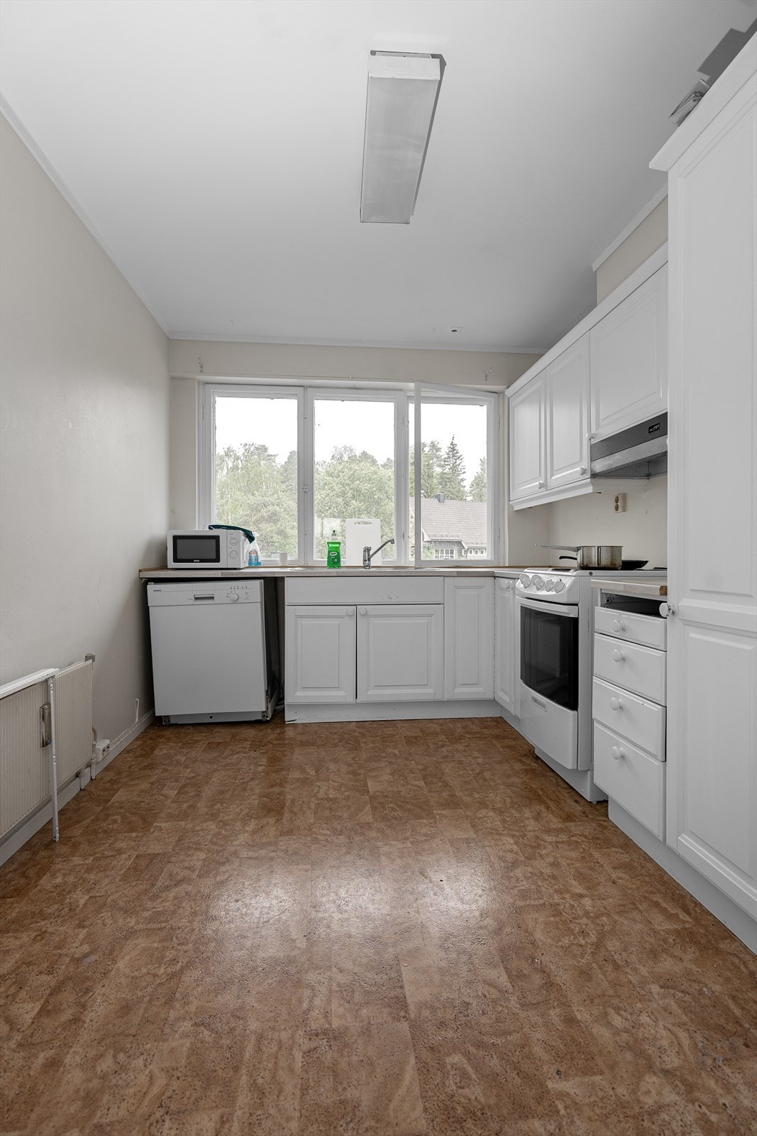 Leiligheten har et lyst og praktisk separat kjøkken. God skap og benkeplass i innredningen som har hvite profilerte fronter og laminert benkeplate med nedfelt oppvaskkum. Galleribilde