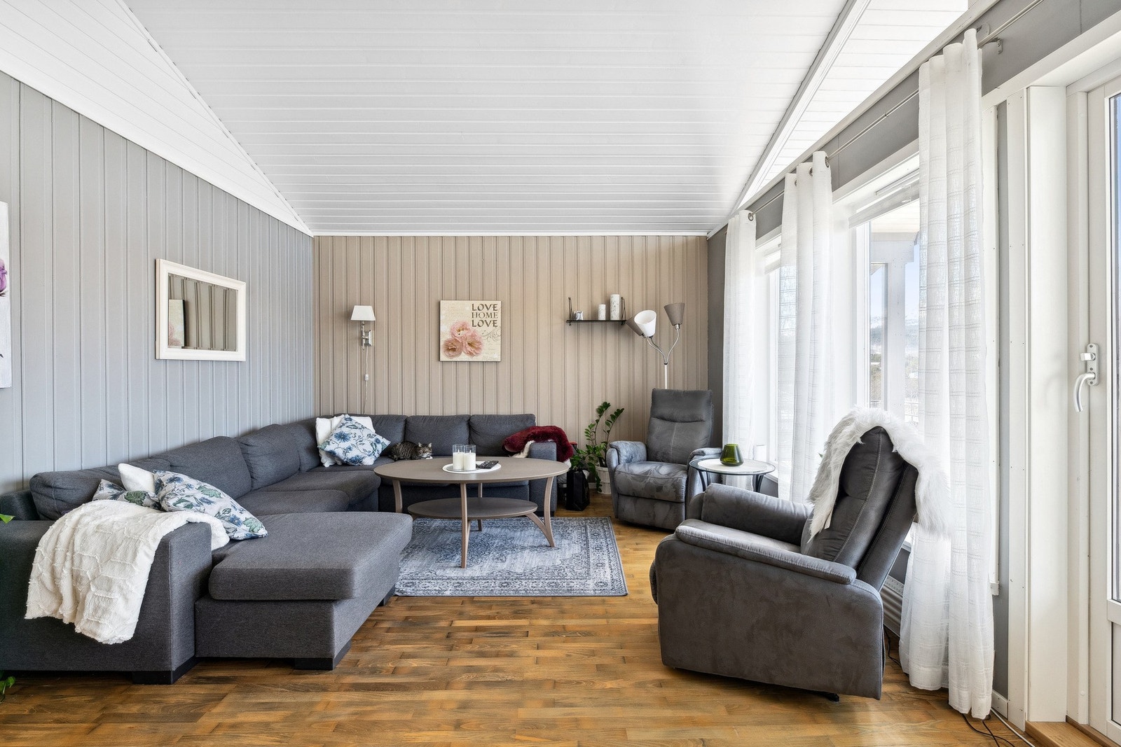 Store vinduer gir rikelig med naturlig lys i stua Galleribilde