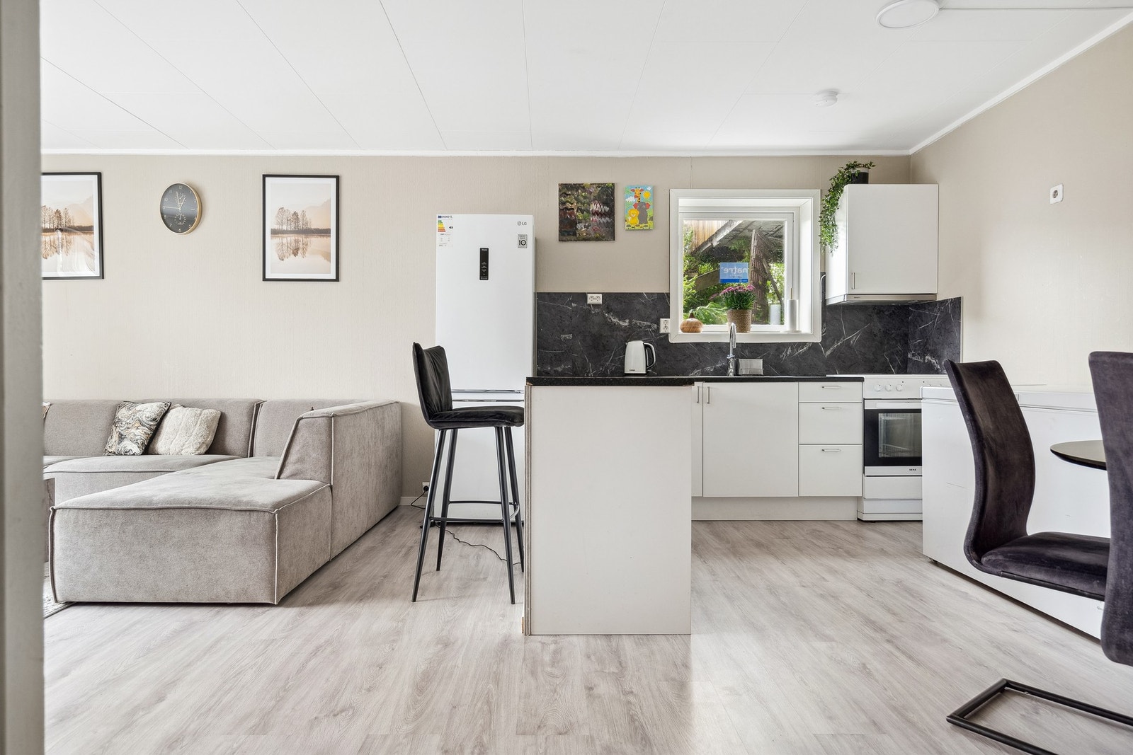 Åpen stue/kjøkken løsning med nyere gulv og kjøkkeninnredning. Galleribilde