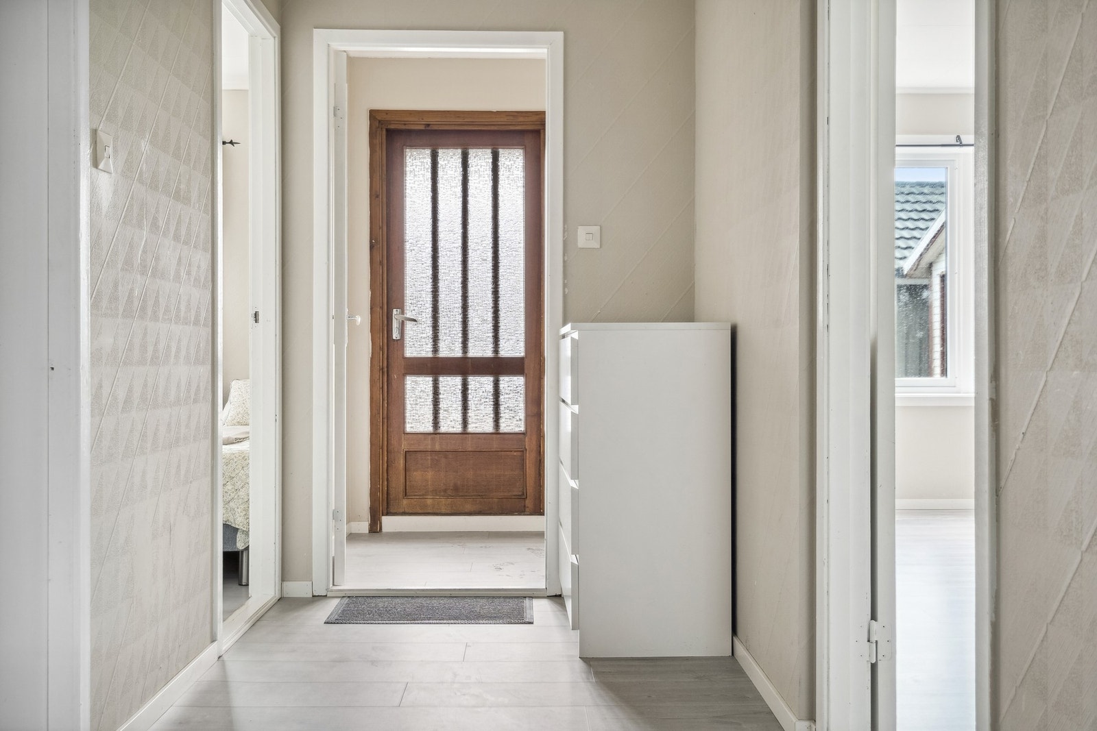 Lys entrè med gang som tar en videre inn i leiligheten. Galleribilde