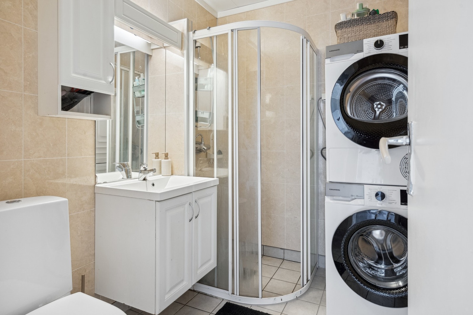 Badet er utstyrt med varmekabler på gulvet, servant i møbel, toalett og opplegg for vaskemaskin. Galleribilde