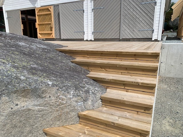 Flotte stedbygde trapper ned til brygga, hvor det er bygget rundt og på en veldig fin måte er innlemmet en av de store steinene som naturlig hører til på tomten. Galleribilde