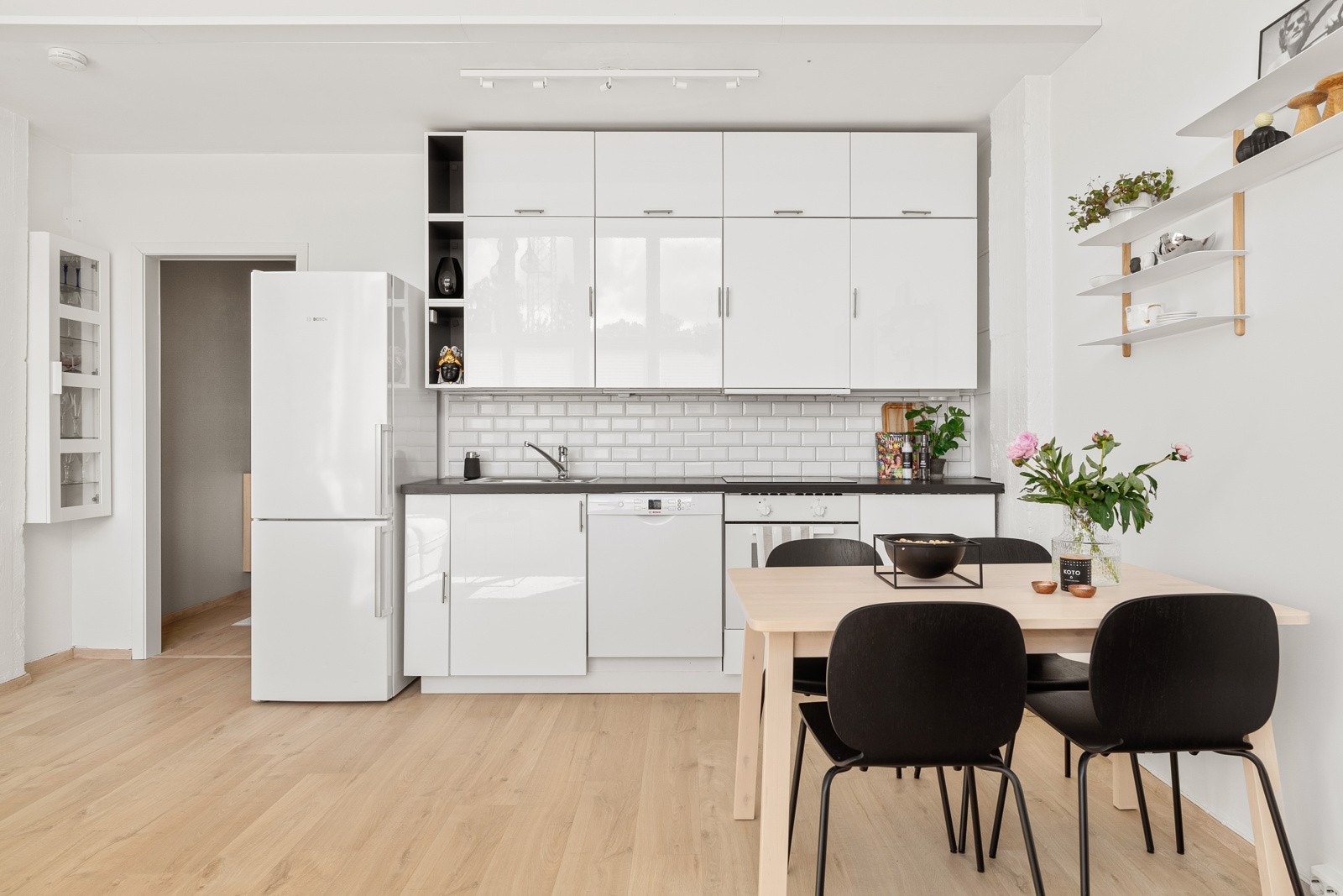Kjøkkenet er smakfullt med en innredning bestående av hvite fronter med glans og en mørkere benkeplate som bryter fint opp de øvrige fargene. Galleribilde